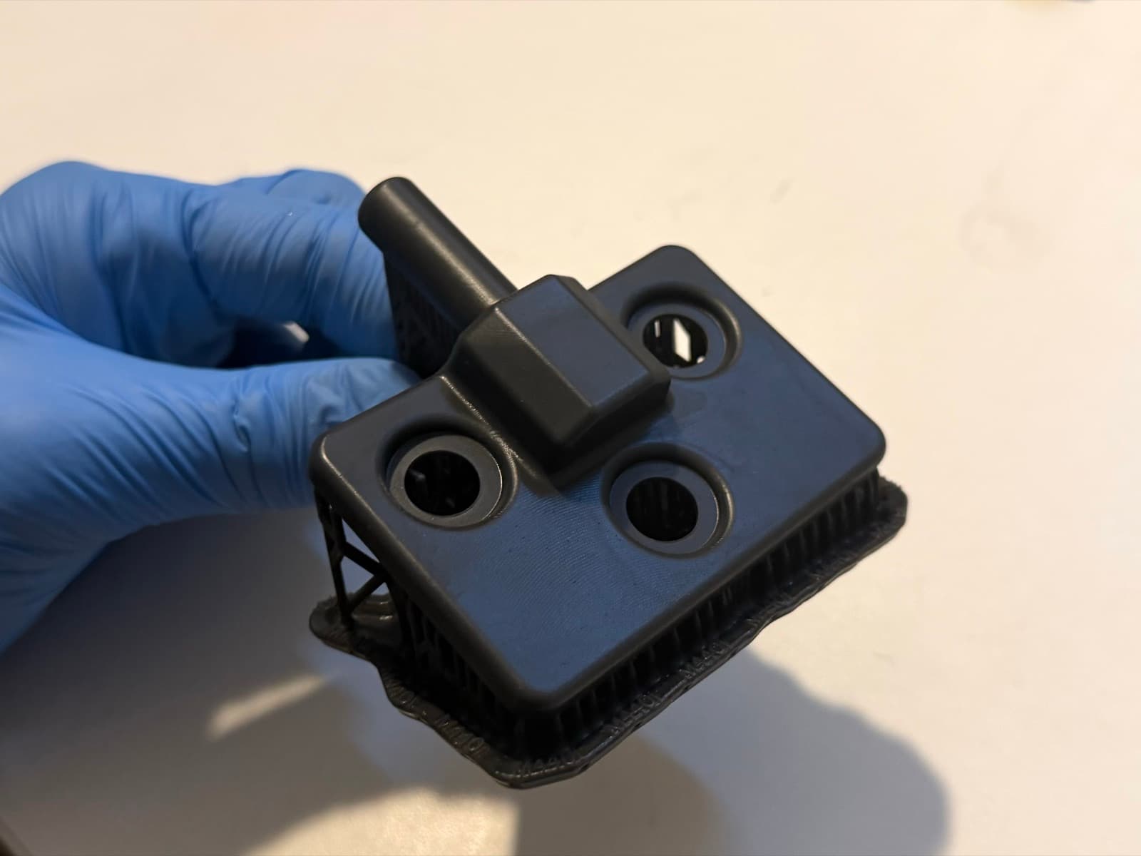 3D printed bracket fresh off the printer with support structures