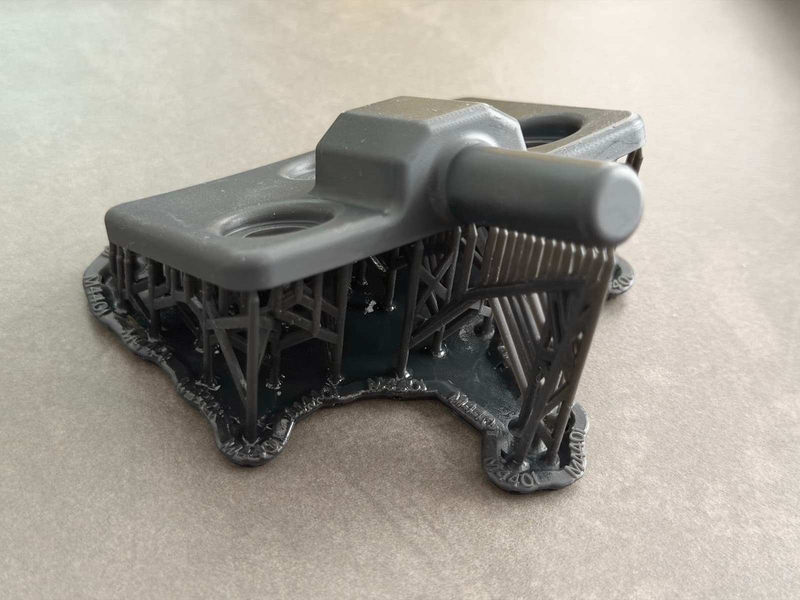 Close-up of the SLA printed bracket on its support lattice before cleanup